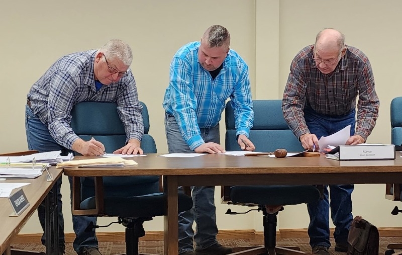 Re-elected as City Councilman Rondal Krysl, newly elected Mayor Josh Erikson, and re-elected City Councilman Scott Shane sign the Oath of Office on Dec. 5 at the Atkinson City Council Meeting.
